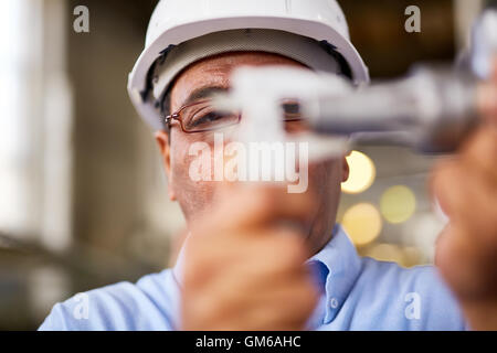 Grave lavoratore manuale in occhiali dettaglio di misurazione Foto Stock