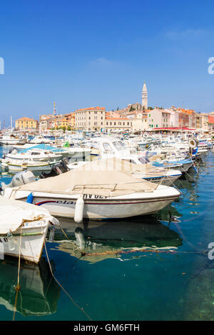 Barche ormeggiate nel porto dominato da i colorati edifici della città vecchia di Rovigno, Istria, Croazia Foto Stock