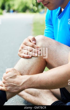 Uomo con sport pregiudizio subito durante il jogging nel parco Foto Stock