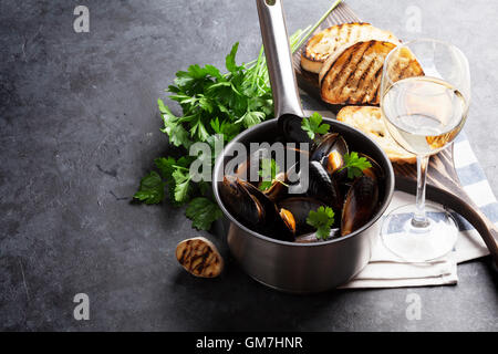 Cozze, crostini di pane e vino bianco sul tavolo di pietra. Vista con lo spazio di copia Foto Stock