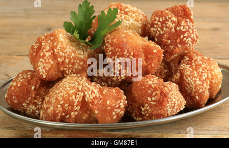 Indiano marasay dolci di riso fritti sfere immerso in semi di sesamo Foto Stock