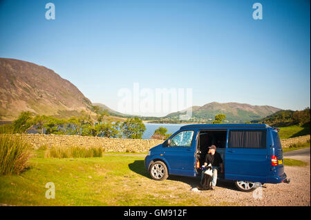 Uomo e cane in van accanto a Crummock acqua in Cumbria Lake District, Inghilterra Foto Stock