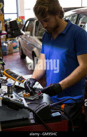 Il fissaggio meccanico di un sistema elettronico di parti di automobili nel suo laboratorio Foto Stock