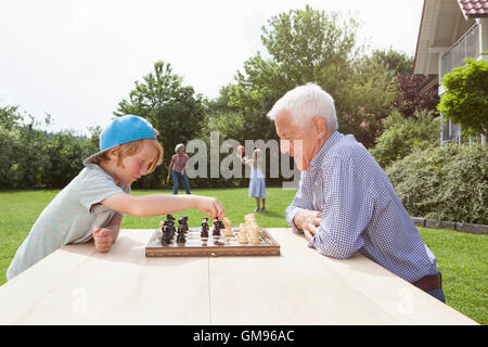 Nonno e nipote a giocare a scacchi in giardino Foto Stock