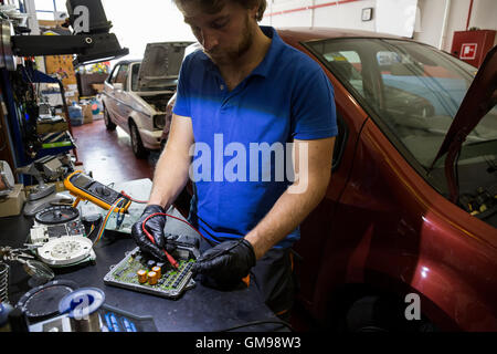 Il fissaggio meccanico di un sistema elettronico di parti di automobili nel suo laboratorio Foto Stock