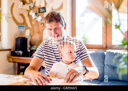 Father and son reading book at home Foto Stock