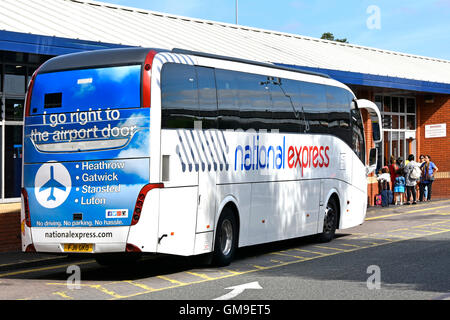 La National Express UK autobus che arrivano a Coventry 'pool' di Prato West Midlands stazione degli autobus con la pubblicità per airport percorsi sul retro del bus Inghilterra Foto Stock