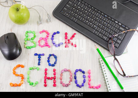 Si torna a scuola scritto con pietre colorate e strumenti di apprendimento Foto Stock