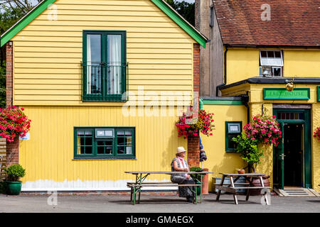 Una donna si siede da solo al di fuori di un Pub di campagna in East Sussex, Regno Unito Foto Stock