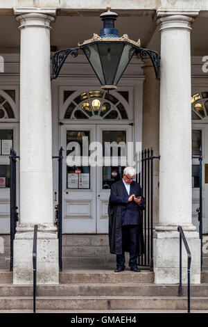 Un avvocato si erge sulle fasi di Lewes Crown Court Texting, Lewes, East Sussex, Regno Unito Foto Stock