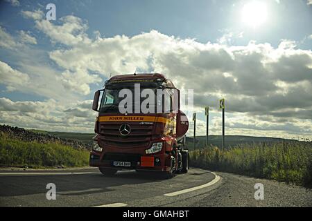 Colpo frontale di una Mercedes Actros tanker azionato da John Miller di Lockerbie arrotonda un ripida curva sulla A623 in una giornata di sole Foto Stock