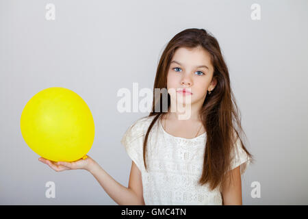Ritratto di un affascinante brunette bambina, isolata su uno sfondo grigio Foto Stock
