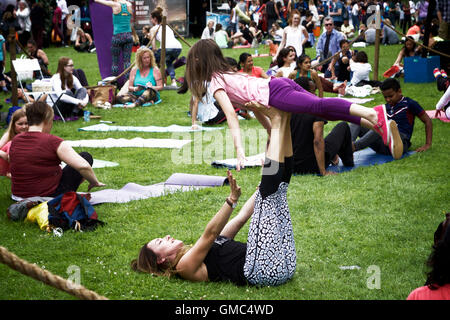 Lo Yoga pone: madre bambino presso la International Yoga giorno a Alexandra Palace, a nord di Londra, Regno Unito. Foto Stock