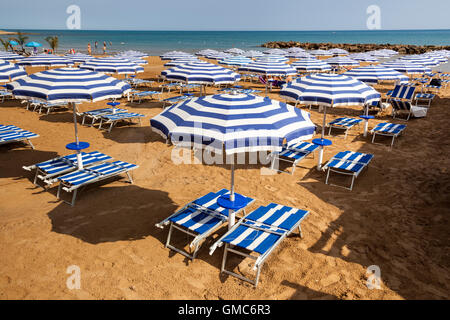Ombrelloni e lettini in spiaggia, Marina di Ragusa, Sicilia, Italia Foto Stock