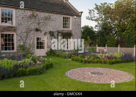 Pavimentazione circolare design e fiori in bella e tradizionale, progettato e paesaggistici, giardino privato - North Yorkshire, Inghilterra. Foto Stock