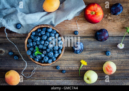 Frutti e bacche su sfondo di legno. Frutta colorata laici piatta Foto Stock