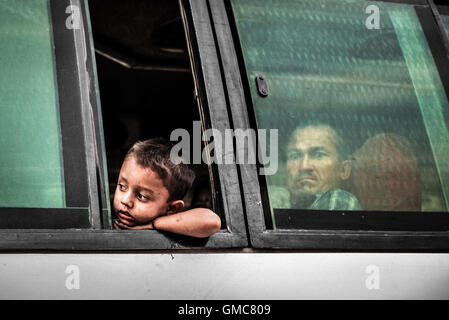 Passeggeri dell'autobus che guardano fuori dalla finestra in una giornata intensa a Kathmandu, un anno dopo il terremoto del Nepal del 2015. Foto Stock