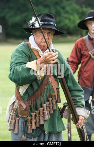 Guerra Civile Inglese Royalist soldato prepara il suo moschetto ad una rievocazione storica, Spetchley Park, Worcestershire, Inghilterra Foto Stock