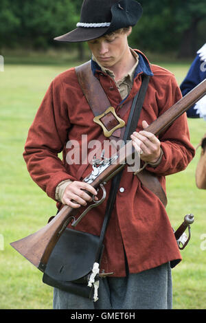 Guerra Civile Inglese Royalist soldato prepara il suo moschetto ad una rievocazione storica, Spetchley Park, Worcestershire, Inghilterra Foto Stock