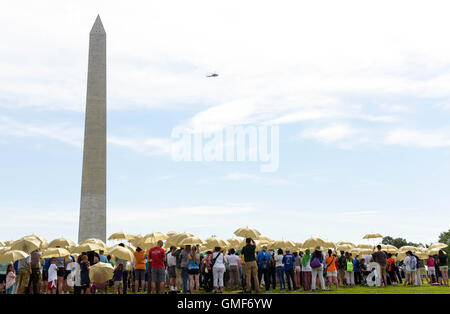 Washington, DC, e il agosto 25. 25 Ago, 2016. Le persone in attesa di ombrelli durante la fase di assemblaggio in una versione vivente del National Park Service iconici emblema per celebrare il centesimo anniversario della U.S. Parchi nazionali sistema, vicino al Monumento di Washington sul National Mall di Washington, DC, Stati Uniti, e il agosto 25, 2016. Il Parco nazionale di servizio 100 gira su agosto 25, 2016. Credito: Bao Dandan/Xinhua/Alamy Live News Foto Stock