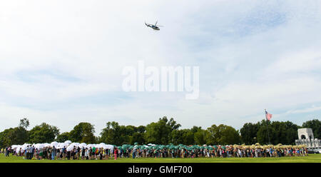 Washington, DC, e il agosto 25. 25 Ago, 2016. Le persone in attesa di ombrelli durante la fase di assemblaggio in una versione vivente del National Park Service iconici emblema per celebrare il centesimo anniversario della U.S. Parchi nazionali sistema, vicino al Monumento di Washington sul National Mall di Washington, DC, Stati Uniti, e il agosto 25, 2016. Il Parco nazionale di servizio 100 gira su agosto 25, 2016. Credito: Bao Dandan/Xinhua/Alamy Live News Foto Stock