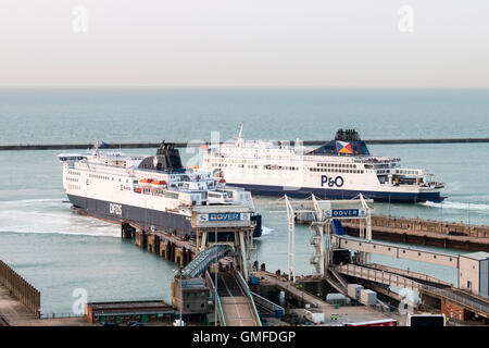 Inghilterra, Dover, Porto. Due navi traghetto, uno, DFDS docking a Dover Ferry Terminal, l'altra, P&O USCIRE, prima luce. Coperto. Foto Stock