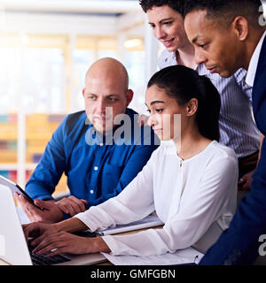 La gente di affari in cerca di informazioni su notebook e tablet Foto Stock