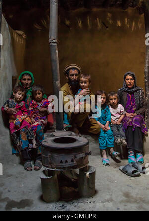 Famiglia afghana nella parte anteriore di una stufa, Badakshan provincia, Khandood, Afghanistan Foto Stock