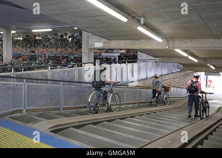 Interno di un nuovo multi-storey bike park a Cambridge nel Regno Unito. Mostra gli utenti sulla rampa di accesso con passaggi poco profonde e rampe di bici Foto Stock