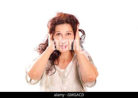 Attraente donna di mezza età che copre le sue orecchie con le mani imitando la scimmia buddhistic, sentire alcun male, isolato su bianco Foto Stock