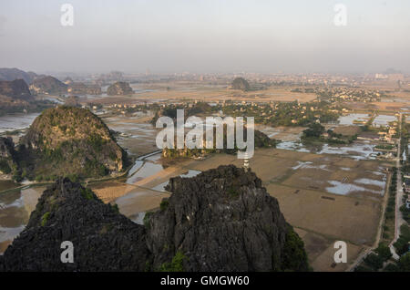 Un fantastico panorama vista dei campi di riso, rocce calcaree e cima Pagoda da appendere Mua tempio di sera. Ninh Binh, Vie Foto Stock