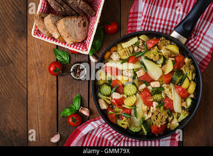 Menu dietetici. Verdure al vapore con filetto di pollo nella padella sullo sfondo di legno. Vista superiore Foto Stock