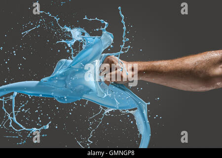 Close-up di un uomo di pugno la punzonatura attraverso il liquido Foto Stock