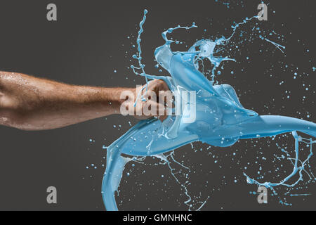 Close-up di un uomo di pugno la punzonatura attraverso il liquido Foto Stock