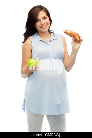 Felice donna incinta con Apple e croissant Foto Stock