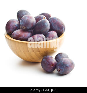 Prugne fresche dal giardino nella ciotola di legno isolato su sfondo bianco. Foto Stock