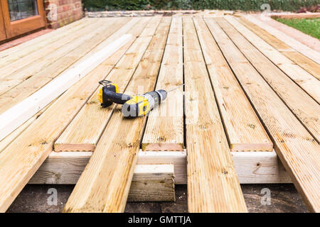 Un nuovo legno, ponte di legno essendo costruito. esso è parzialmente completato. un trapano può essere visto sul decking. Foto Stock