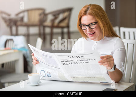 Gioioso donna sorpresa in appoggio nel cafe Foto Stock