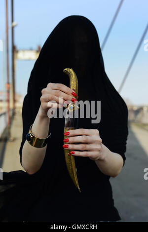 Ragazza in nero con un pugnale orientale Foto Stock