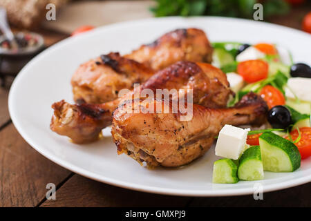 Appetitosa cotta nel forno golden pollo Cosce di pollo disossate e insalata greca Foto Stock