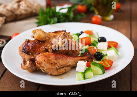 Appetitosa cotta nel forno golden pollo Cosce di pollo disossate e insalata greca Foto Stock