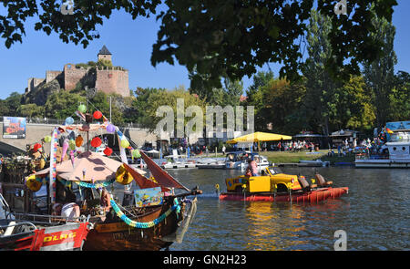 Halle, Germania. Il 27 agosto, 2016. Un partecipante della festa delle lanterne rigidi sul fiume Saale con un convertito Trabant (r) a Halle, Germania, 27 agosto 2016. La festa tradizionale che risale all'anno 1928, si svolgerà fino a Domenica (28 agosto 2016). Uno dei punti forti è, oltre alla sfilata di barche, i pescatori tradizionali di giostre del sale-panners, in cui giovani uomini in barche di provare a lanciare ogni altro nel fiume con aste. Foto: Hendrik Schmidt/dpa/Alamy Live News Foto Stock