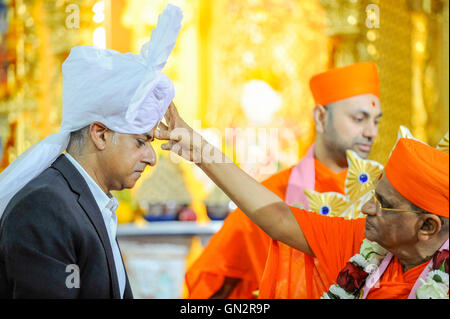 Londra, Regno Unito. Il 28 agosto 2016. Sadiq Khan, sindaco di Londra, indossa un Paag, un turbante speciali riservati per i leader della comunità e riceve una tilak-chandlo da global leader spirituale Acharya Swamishree Maharaj a Shree Swaminarayan Mandir, un tempio indù di Kingsbury, a nord ovest di Londra. Il sindaco era in visita al tempio per ringraziare la Congregazione per le loro preghiere e benedizioni durante il suo Mayoral campagna e per celebrare il secondo anniversario del mandir. Credito: Stephen Chung / Alamy Live News Foto Stock