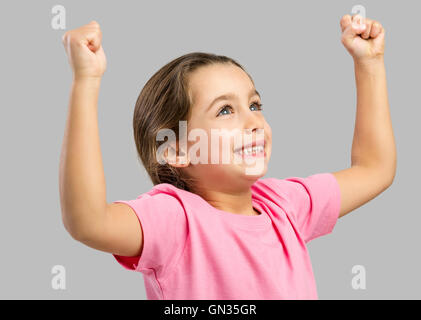 Ritratto in studio di un felice bambina con le braccia sollevate in aria Foto Stock