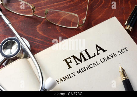 Pagina con FMLA Family Medical Leave Act su un tavolo. Foto Stock