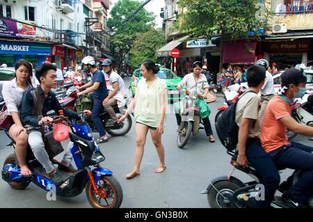 Hanoi, Vietnam - 20 novembre 2015. La donna sta tentando di attraversare la strada nella città vecchia di Hanoi e Foto Stock