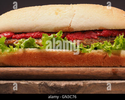 Closeup colpo di una deliziosa burger su una tavola in legno rustico Foto Stock