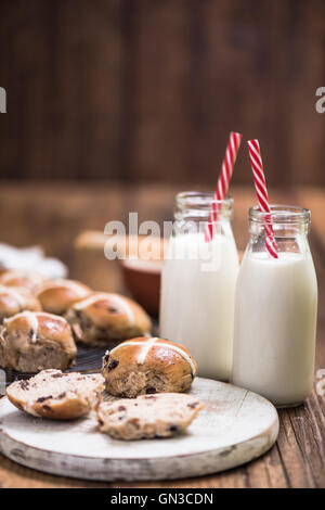 Hot cross i panini con latte sulla tavola di legno Foto Stock