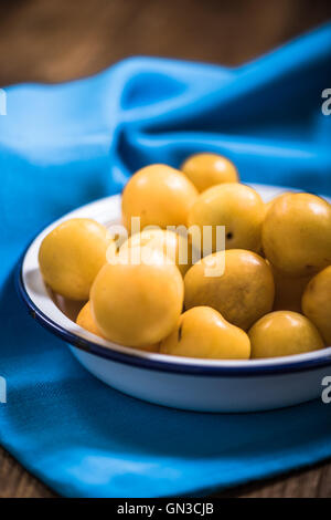 Fresche e mature prugne giallo nel recipiente Foto Stock