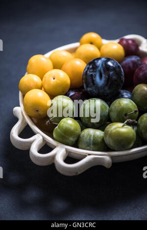 In autunno le prugne dal mercato locale nel recipiente rustico, Foto Stock